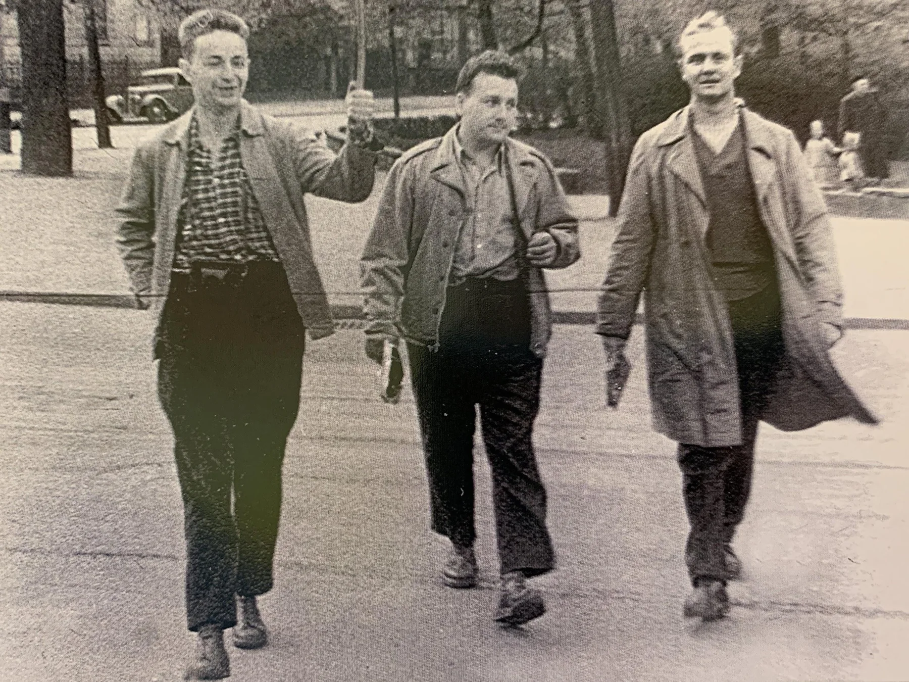 Three young scientists walking outdoors, with Andrzej Ruprecht at right