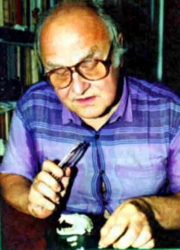 Andrzej Ruprecht holding a small specimen at his desk